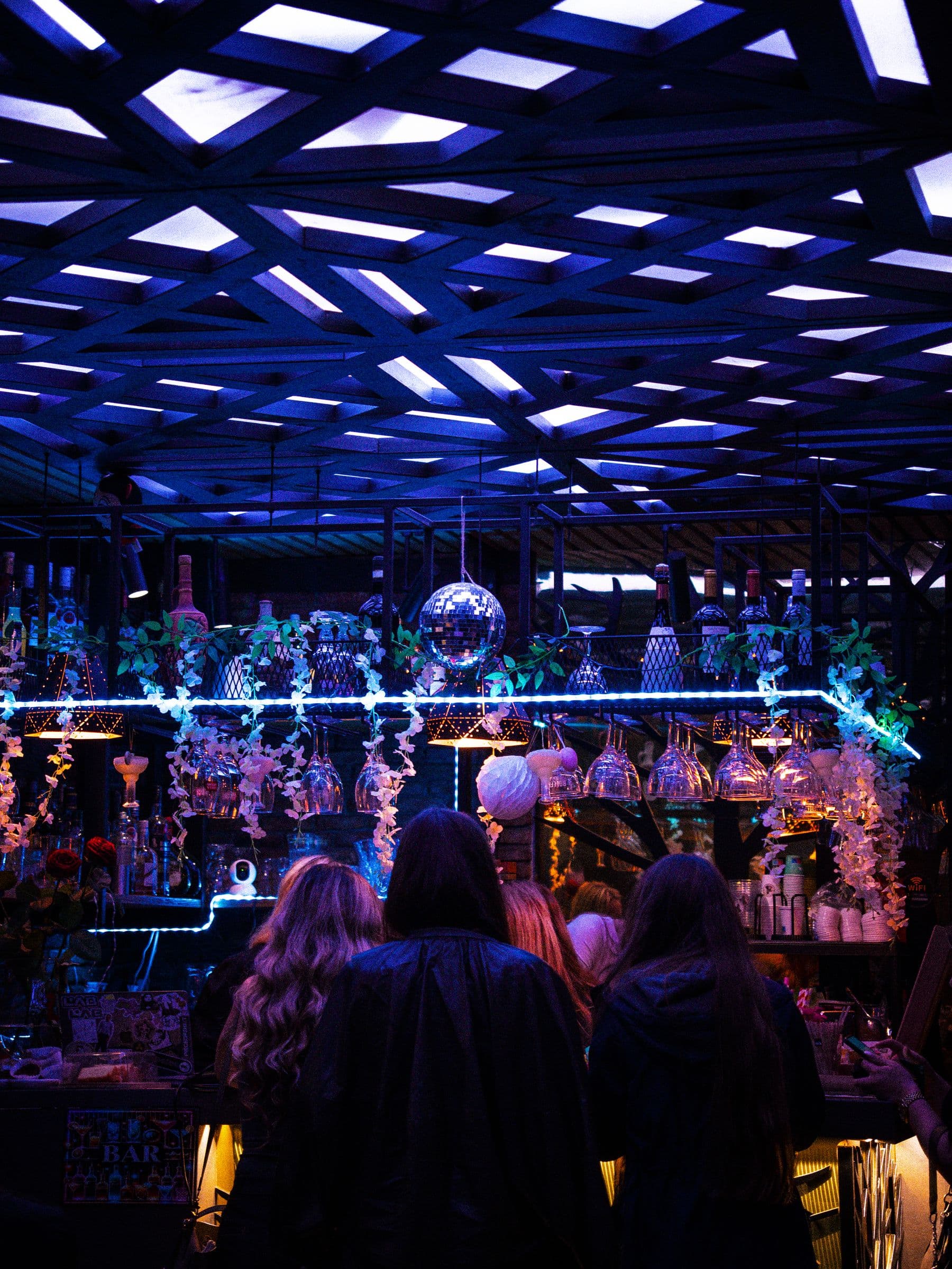 The back bar at night under the blue-lit ceiling.